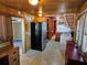 Kitchen with wood paneled walls, black refrigerator and view to laundry area at 1424 Lake Shore Dr, Casselberry, FL 32707