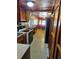 A galley kitchen with wood paneling and cabinetry, with white appliances and view to breakfast nook at 1424 Lake Shore Dr, Casselberry, FL 32707