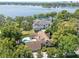Expansive aerial view showcasing a home, pool, and lush landscape, with a picturesque lake backdrop at 1742 Barcelona Way, Winter Park, FL 32789