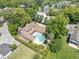 An aerial shot showcases a luxurious home with a pool surrounded by lush landscaping and mature trees at 1742 Barcelona Way, Winter Park, FL 32789