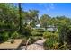 Beautiful backyard with lush greenery, brick pathway, and a tranquil water view, offering a serene outdoor escape at 1742 Barcelona Way, Winter Park, FL 32789