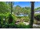 Backyard patio featuring a table and chairs with a lush garden and water view at 1742 Barcelona Way, Winter Park, FL 32789