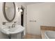 Bathroom with decorative sink, mirror, sconce, and a textured tiled shower area at 1742 Barcelona Way, Winter Park, FL 32789