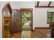 Inviting home foyer featuring tiled floors, fireplace, and view to a garden through a wooden door at 1742 Barcelona Way, Winter Park, FL 32789