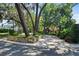 Home exterior with mature trees shading the property, complemented by a stone wall and paved driveway at 1742 Barcelona Way, Winter Park, FL 32789