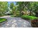 Home exterior featuring a well-maintained lawn, brick driveway, and lush landscaping at 1742 Barcelona Way, Winter Park, FL 32789