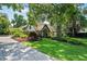 Inviting home exterior showcasing a lush lawn and brick driveway framed by mature trees and landscaping at 1742 Barcelona Way, Winter Park, FL 32789