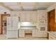 Kitchen features white appliances, white cabinets, and built-in desk area for added functionality at 1742 Barcelona Way, Winter Park, FL 32789