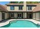 Backyard pool with steps offers a refreshing escape, complemented by the classic architecture of the home's exterior at 1742 Barcelona Way, Winter Park, FL 32789