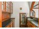 Well-appointed wet bar featuring custom cabinetry, granite counters, and beverage cooler at 1742 Barcelona Way, Winter Park, FL 32789
