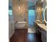 Luxurious bathroom with a freestanding tub, patterned accent wall, and modern vanity with ample counter space at 1802 Hartford Path, The Villages, FL 32162