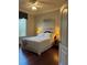 Comfortable bedroom with wood floors, neutral walls, and a serene ambiance with a large window at 1802 Hartford Path, The Villages, FL 32162