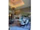 Open-concept dining room featuring an elegant chandelier, wood paneled walls, and seamless access to other living spaces at 1802 Hartford Path, The Villages, FL 32162