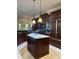 Beautiful kitchen features marble floors, dark wood cabinets, granite counters, stainless steel appliances, and island at 1802 Hartford Path, The Villages, FL 32162