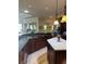 Spacious kitchen with granite counters, center island, stainless appliances, and stylish hanging lights at 1802 Hartford Path, The Villages, FL 32162