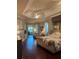 Spacious main bedroom with hardwood floors, a tray ceiling, and access to an outdoor space at 1802 Hartford Path, The Villages, FL 32162