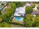 Aerial view of a property showcasing a modern home, pool, spa, wooden deck, and lush landscaping at 1831 Mizell Ave, Winter Park, FL 32789