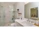 Bathroom features a glass shower with a tiled wall, white vanity, and storage shelves, offering modern convenience at 1831 Mizell Ave, Winter Park, FL 32789