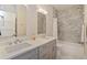 Bathroom showcasing double sinks, grey shaker cabinets, tiled walls, and a bathtub with a shower at 1831 Mizell Ave, Winter Park, FL 32789