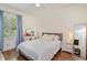 Well-lit bedroom featuring a bed, a window with blue curtains, a ceiling fan, and a small desk with a round mirror at 1831 Mizell Ave, Winter Park, FL 32789
