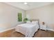 Bright bedroom featuring a queen-size bed, a nightstand, a window, hardwood floors, and neutral-toned walls at 1831 Mizell Ave, Winter Park, FL 32789