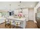 Bright open kitchen with an island, bar stools, white cabinets and stainless appliances at 1831 Mizell Ave, Winter Park, FL 32789