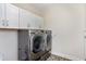 Functional laundry room equipped with a modern washer and dryer, as well as upper cabinet storage at 1831 Mizell Ave, Winter Park, FL 32789