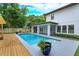 Gorgeous backyard featuring a pool, spa, covered patio, and lush landscaping, creating a relaxing outdoor space at 1831 Mizell Ave, Winter Park, FL 32789
