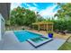 Inviting backyard with a sparkling pool, spa, and wooden deck, complete with a pergola and outdoor seating at 1831 Mizell Ave, Winter Park, FL 32789