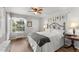 Relaxing bedroom with large window overlooking green outdoor views and ceiling fan at 1956 Lake Atriums Cir # 146, Orlando, FL 32839
