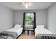 Bedroom features two twin beds, wood floors, ceiling fan, and a view of the lake at 1956 Lake Atriums Cir # 146, Orlando, FL 32839