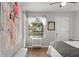 Bright bedroom featuring a window overlooking water, ceiling fan, and light walls at 1956 Lake Atriums Cir # 146, Orlando, FL 32839