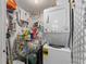 Small laundry room includes a stacked washer and dryer, shelving, and storage space at 1956 Lake Atriums Cir # 146, Orlando, FL 32839