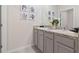 Stylish bathroom featuring double sinks with granite countertops, complemented by elegant decor and a large mirror at 2155 Kalin Way, Tavares, FL 32778
