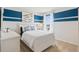 Cozy bedroom with a blue accent wall, comfortable bed, dresser, and ample natural light at 2155 Kalin Way, Tavares, FL 32778