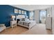 Serene bedroom with a blue accent wall, comfortable bedding, and ample natural light, perfect for relaxation at 2155 Kalin Way, Tavares, FL 32778
