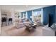 Living room with a sofa, chairs, and a coffee table, with light from two large windows with blue walls at 2155 Kalin Way, Tavares, FL 32778