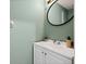 Powder room with vanity, sink, round mirror and green walls at 2239 Meadowmouse St, Orlando, FL 32837