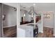 Kitchen showcasing white cabinets, a stainless steel range hood, and white countertops, open to a living room at 2239 Meadowmouse St, Orlando, FL 32837