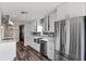 Updated kitchen with white cabinets, stainless steel appliances, stainless steel farmhouse sink and wood floors at 2239 Meadowmouse St, Orlando, FL 32837