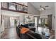 Cozy living room featuring high ceilings, a ceiling fan, a wooden railing, and an adjacent kitchen and dining area at 2239 Meadowmouse St, Orlando, FL 32837