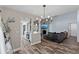 Living room with wood flooring, and gray walls, open to a kitchen with white cabinets and stainless steel appliances at 2239 Meadowmouse St, Orlando, FL 32837