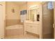 Bright bathroom featuring a soaking tub, walk-in shower, and vanity with ample storage at 2503 Squaw Crk, Clermont, FL 34711