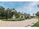 Gated community entrance featuring a water fountain, tropical landscaping, and paved brick road at 2503 Squaw Crk, Clermont, FL 34711