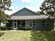 Rear exterior showcasing a well-maintained home with a screened-in patio and lush greenery at 2503 Squaw Crk, Clermont, FL 34711