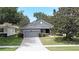 Inviting single-story home featuring a lush green lawn, a brick driveway, and mature trees at 2503 Squaw Crk, Clermont, FL 34711