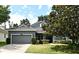 Charming single-story home with a well-manicured lawn, mature trees, and a two-car garage at 2503 Squaw Crk, Clermont, FL 34711