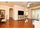Open-concept living room with wood floors, modern furnishings, and a view into the adjacent dining area at 2503 Squaw Crk, Clermont, FL 34711
