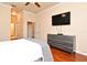 Spacious main bedroom with hardwood floors, ceiling fan, TV, and stylish gray furniture at 2503 Squaw Crk, Clermont, FL 34711