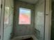 Stylish bathroom featuring a bathtub with a marble-look tile surround and a frosted window at 335 Ruth Blvd, Longwood, FL 32750
